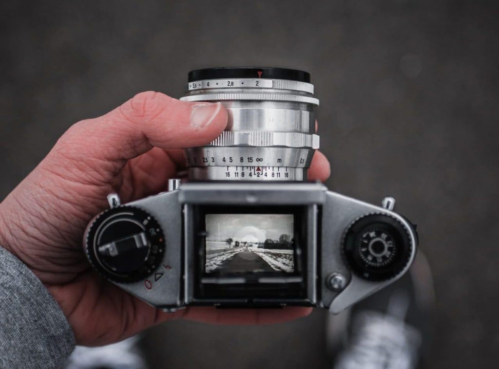 Image of someone taking a picture with an old camera with a top-down viewfinder