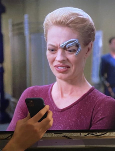 Seven of Nine from Star Trek Voyager looking disgusted at something on a smartphone